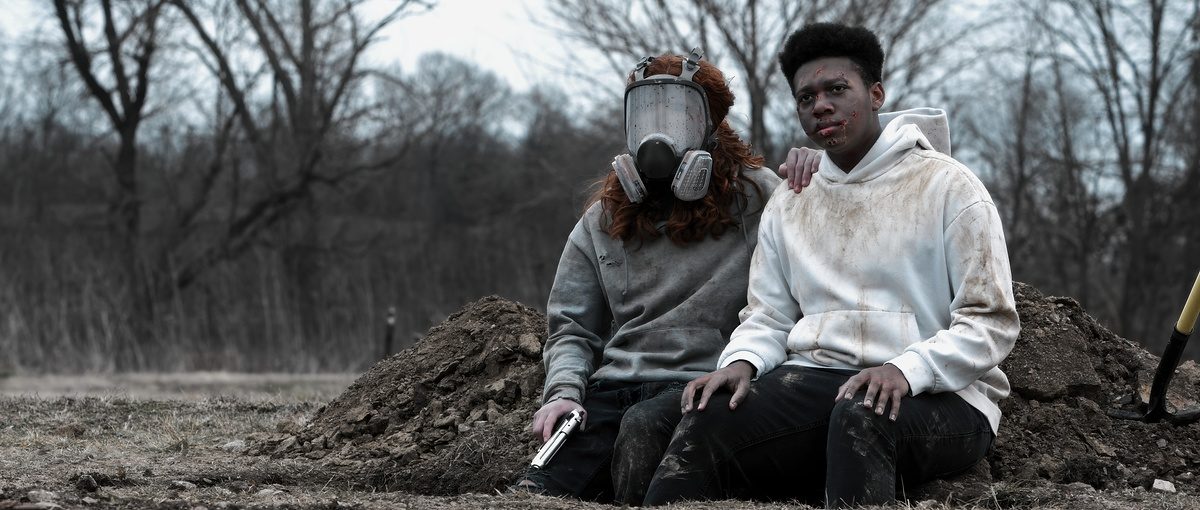 Samuel (Deacon Grasty) and Elijah (Aidan Brooks) sit together beside a freshly dug grave.
